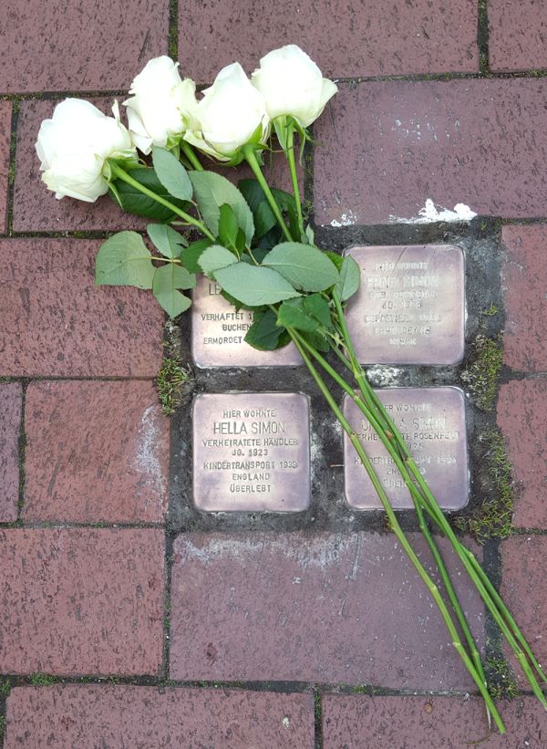 weiße Rosen niederlegt auf die Stolpersteine