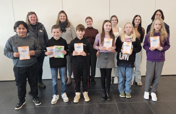 Fünf SchülerInnen und fünf Jurymitglieder vor einer weißen Wand