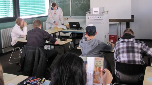 In einem Klassenraum befinden sich einige Schüler, die lesen