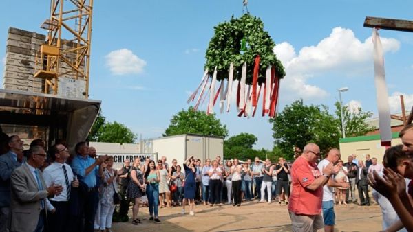 Die Richtkrone wird auf den Rohbau gezogen, Zuschauer