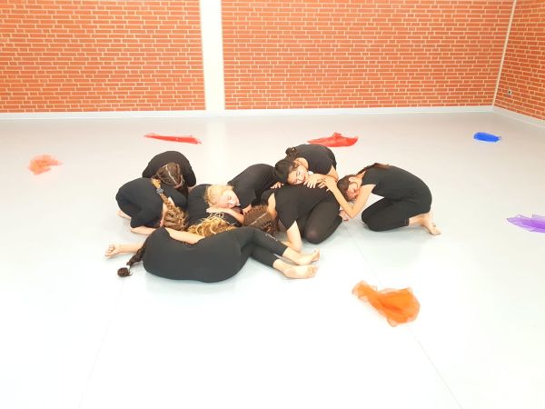 Mädchen in schwarzen Trikots liegen auf dem Boden